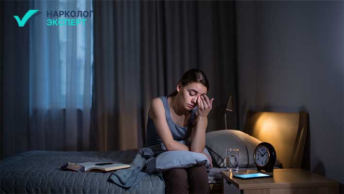 Девушка с бессонницей сидит в кровати